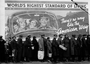 UNITED STATES - CIRCA 1937:  African American flood victims lining up to get food and clothing from a relief station in front of a billboard ironically proclaming WORLD'S HIGHEST STANDARD OF LIVING/THERE'S NO WAY LIKE THE AMERICAN WAY.  (Photo by Margaret Bourke-White/Time & Life Pictures/Getty Images)